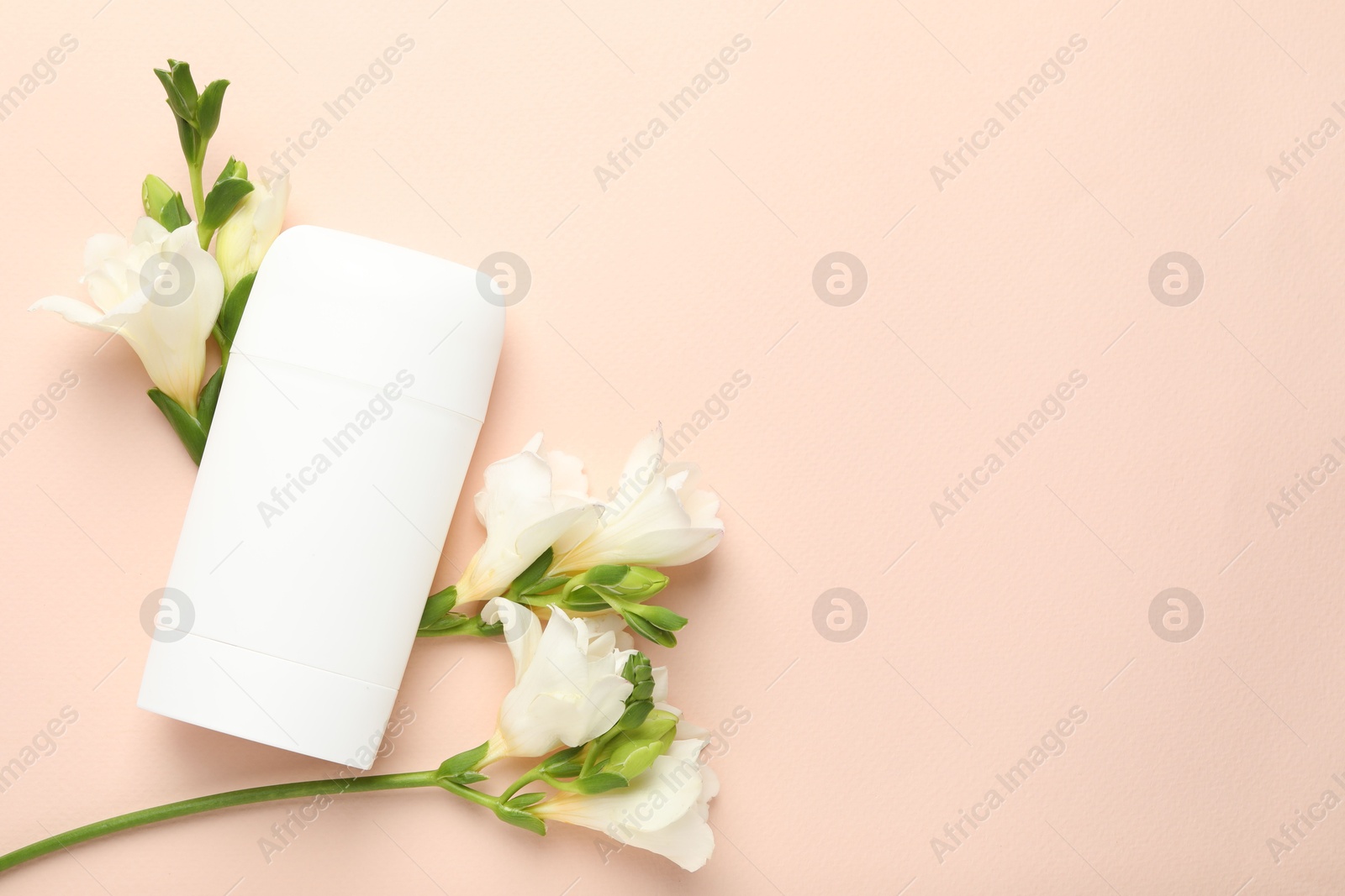 Photo of Solid deodorant and beautiful eustoma flowers on beige background, flat lay. Space for text