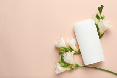 Photo of Solid deodorant and beautiful eustoma flowers on beige background, flat lay. Space for text