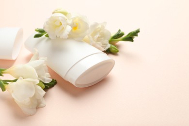 Photo of Solid deodorant and beautiful eustoma flowers on beige background, closeup