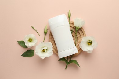 Photo of Solid deodorant and beautiful eustoma flowers on beige background, flat lay