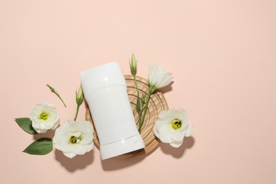 Photo of Solid deodorant and beautiful eustoma flowers on beige background, flat lay. Space for text