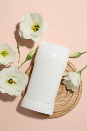 Photo of Solid deodorant and beautiful eustoma flowers on beige background, flat lay