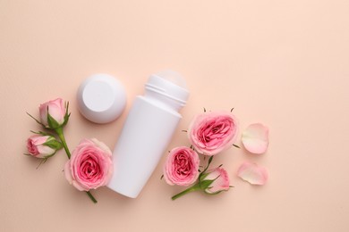 Photo of Roll-on deodorant and beautiful rose flowers on beige background, flat lay