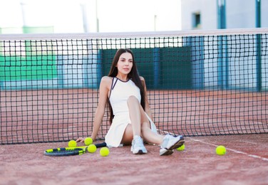 Beautiful woman in sportswear on tennis court