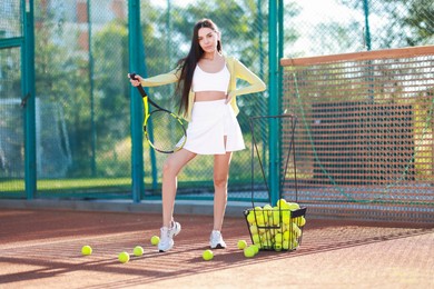 Beautiful woman with tennis racket on court