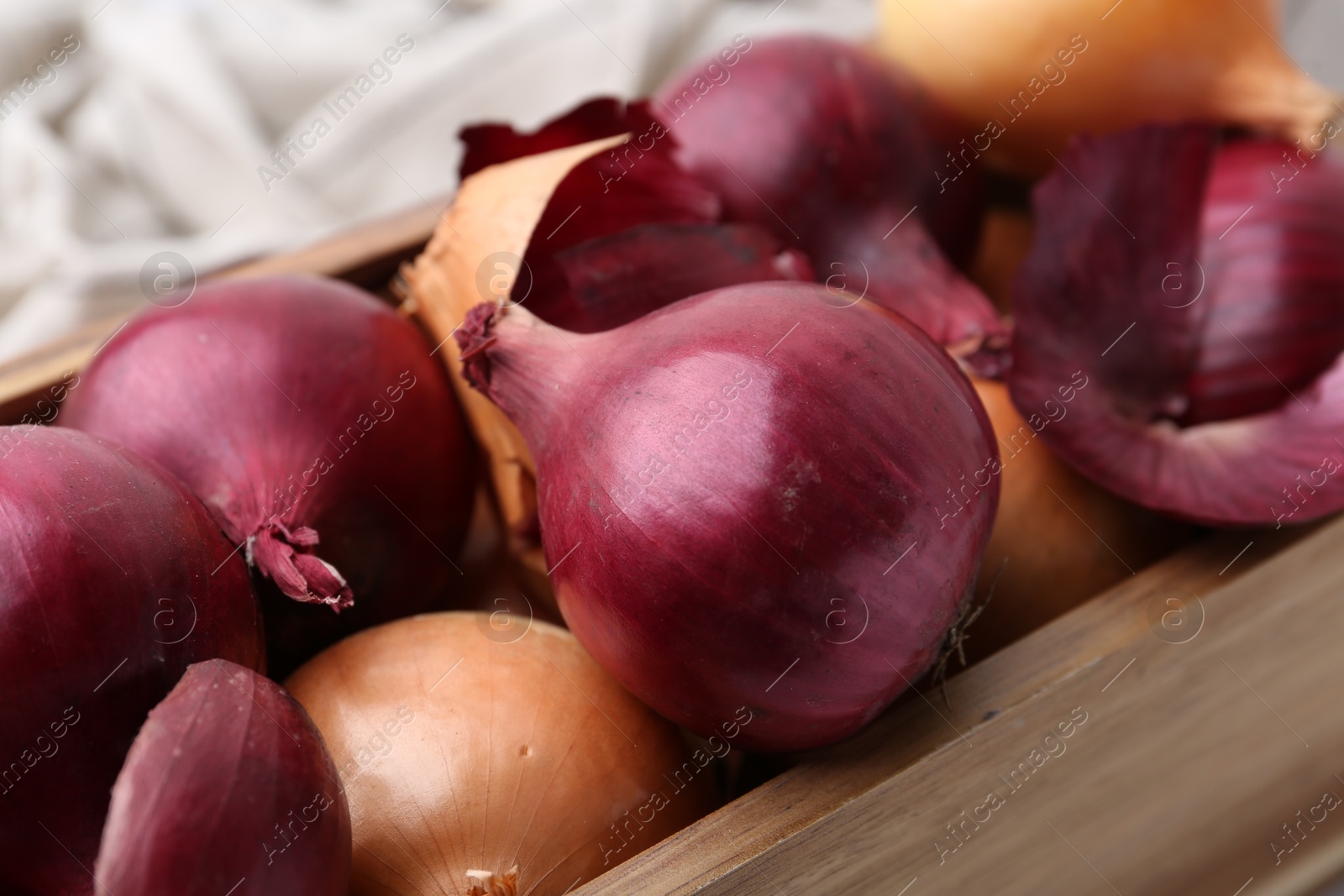 Photo of Crate with fresh onions and peels, closeup