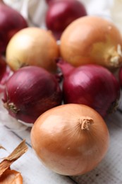 Photo of Fresh onions and peels on table, closeup