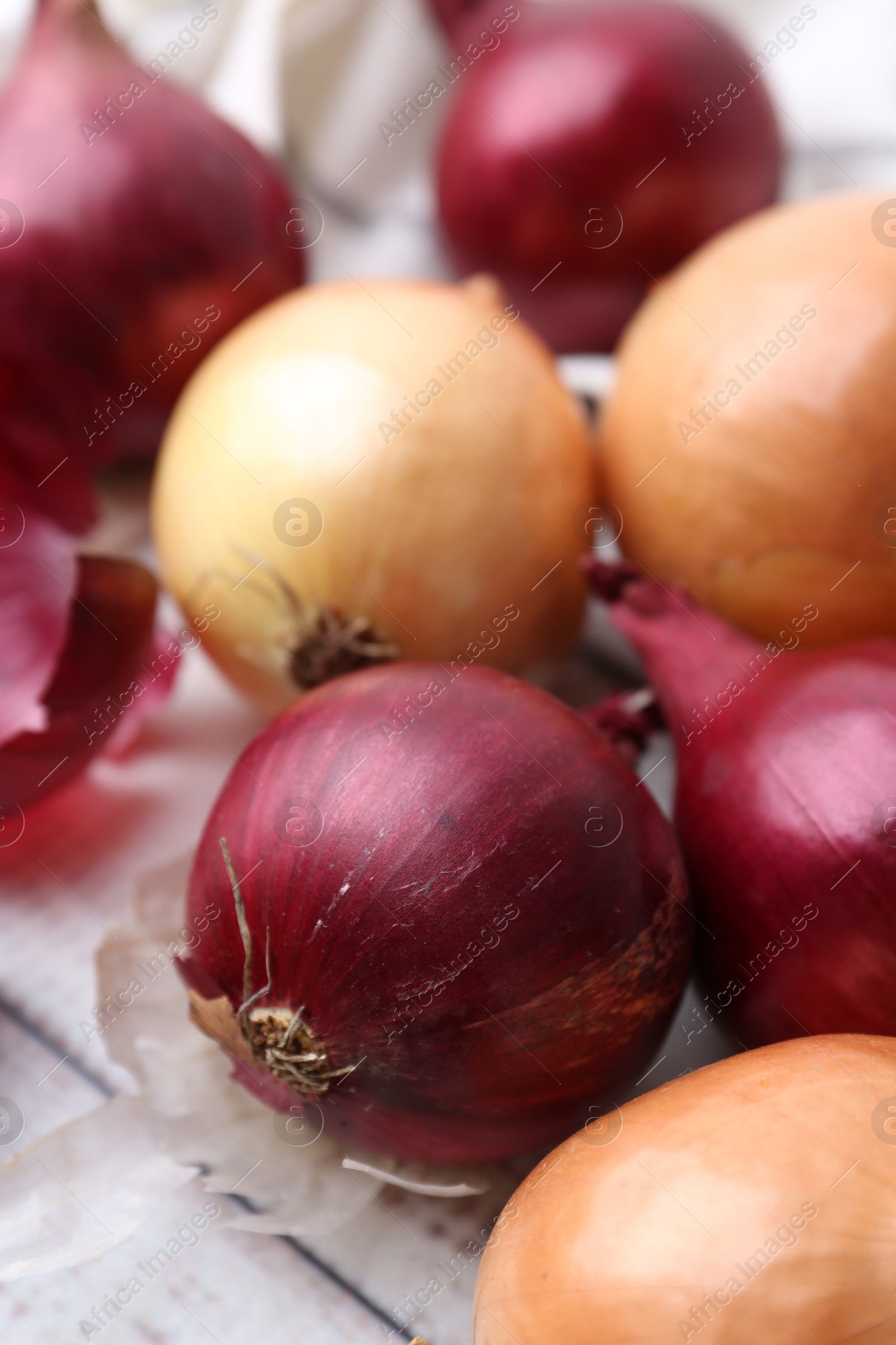 Photo of Fresh onions and peels on table, closeup