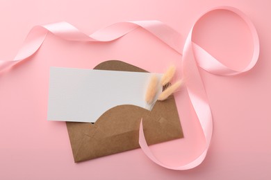 Blank card, envelope, ribbon and spikelets on pink background, top view