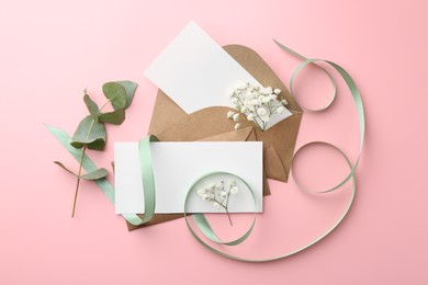 Flat lay composition with blank cards and ribbon on pink background