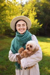 Smiling woman with cute dog in autumn park