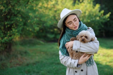 Photo of Woman with cute dog in autumn park. Space for text