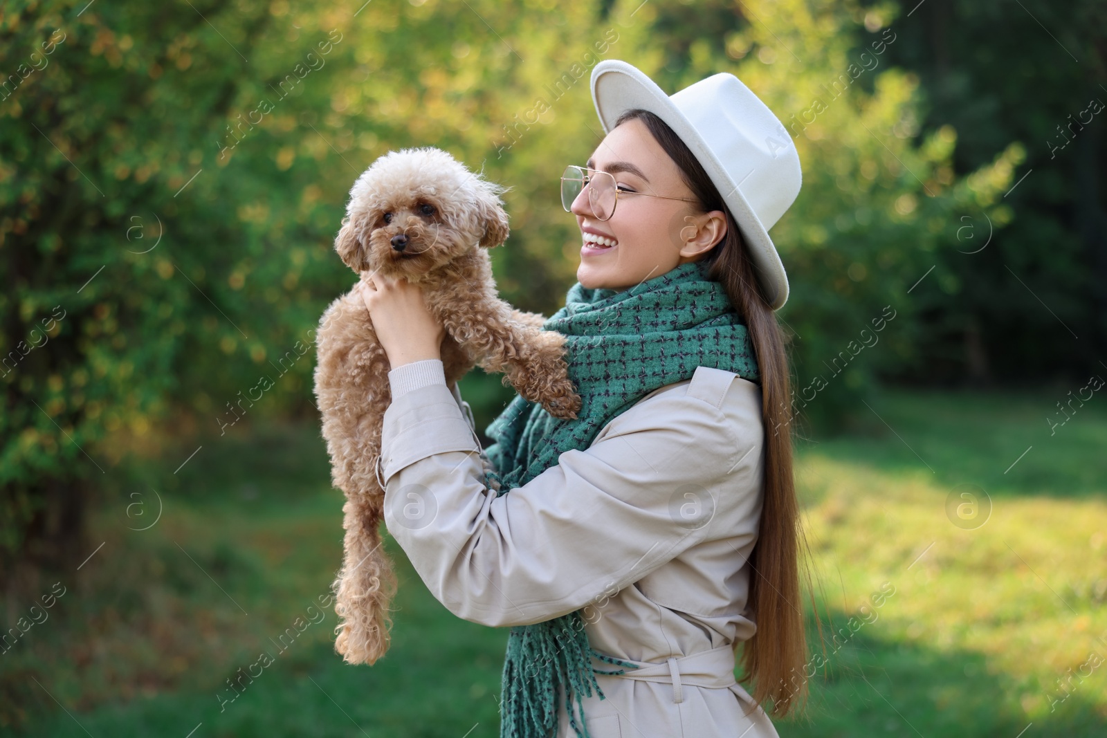 Photo of Smiling woman with cute dog in autumn park