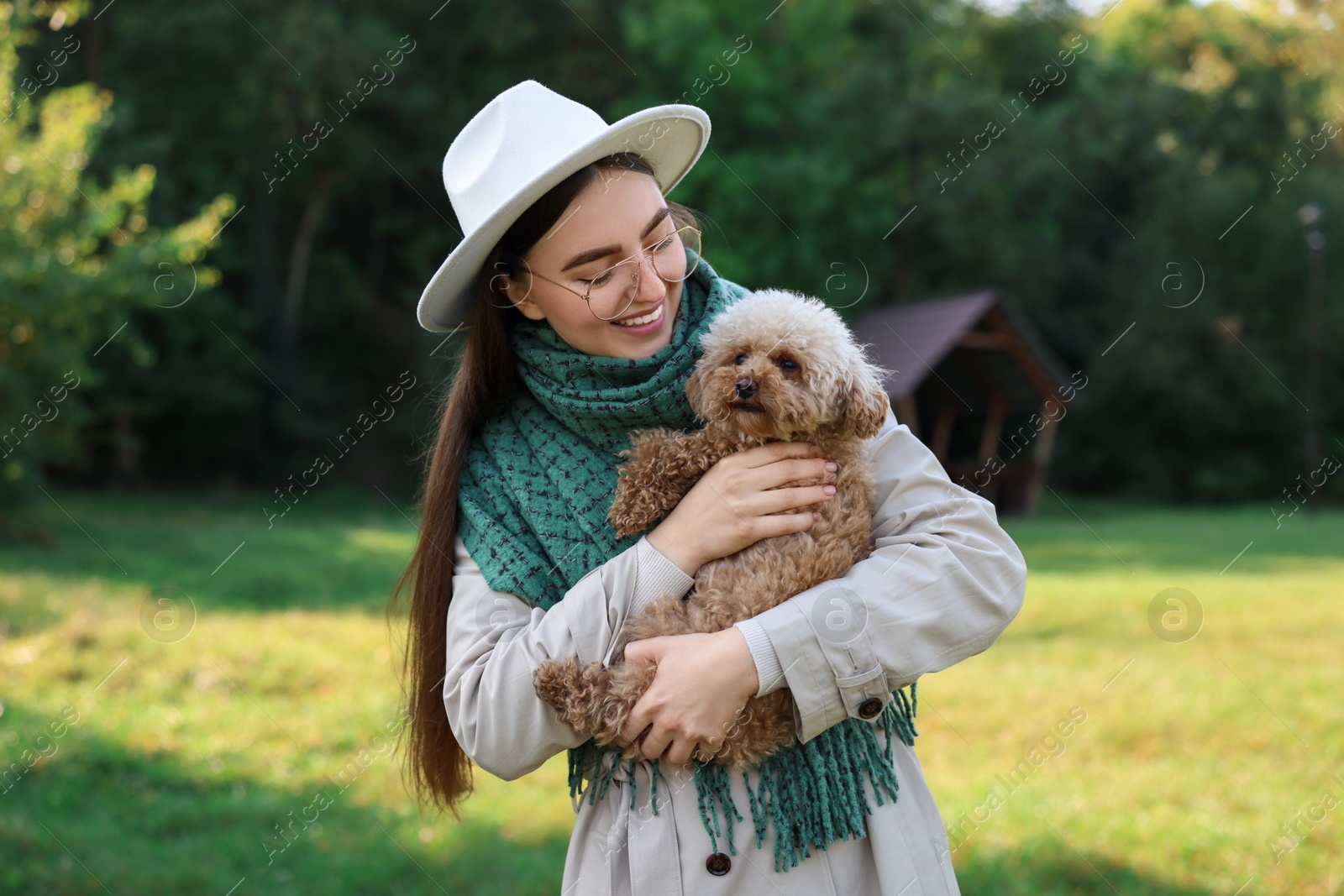 Photo of Smiling woman with cute dog in autumn park