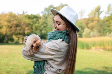 Photo of Smiling woman with cute dog in autumn park