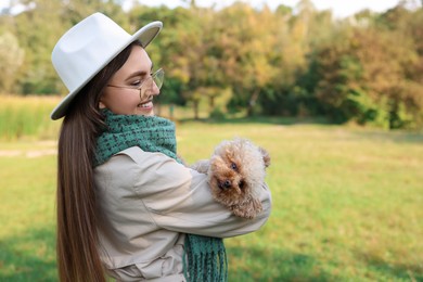 Smiling woman with cute dog in autumn park. Space for text