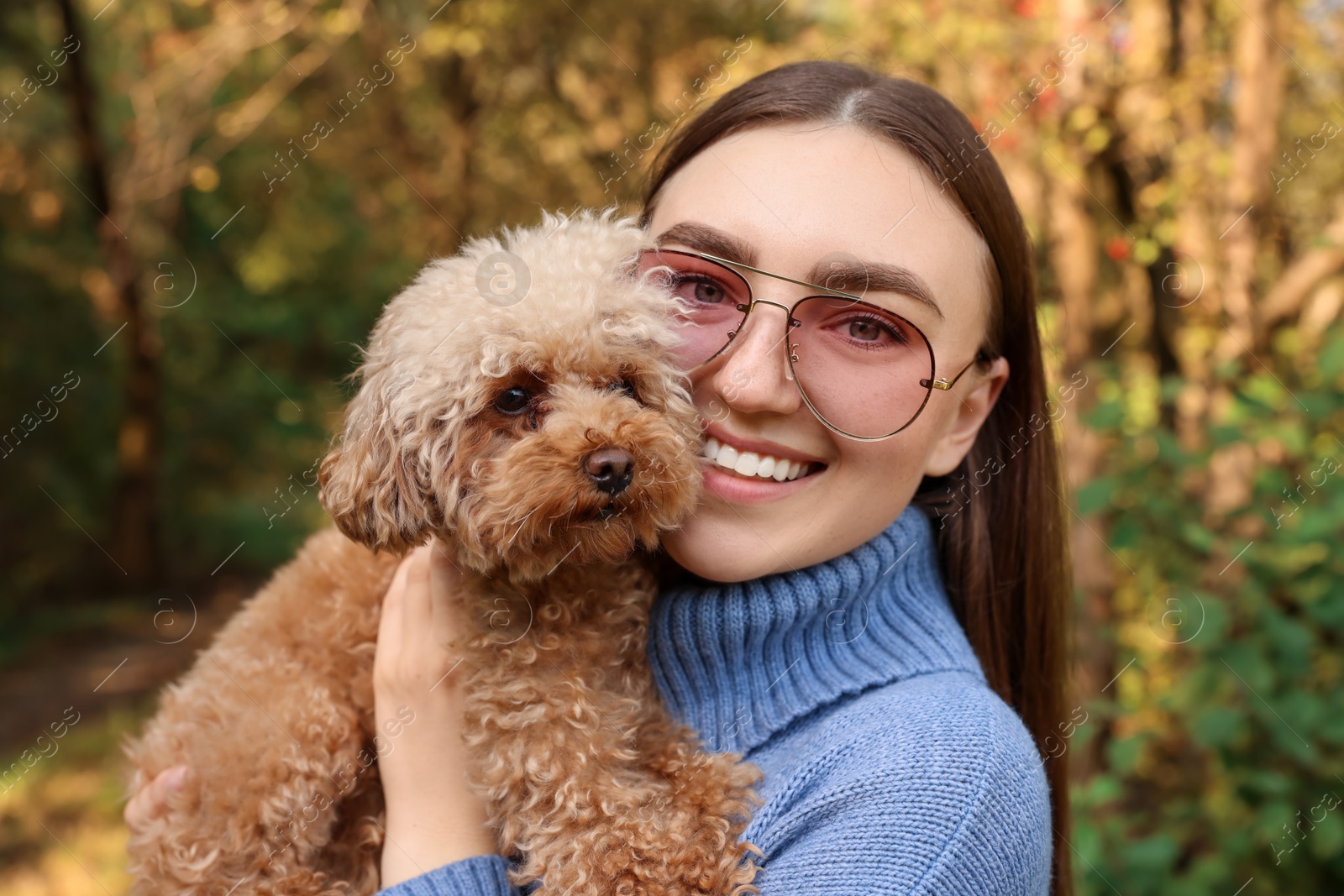 Photo of Smiling woman with cute dog in autumn park