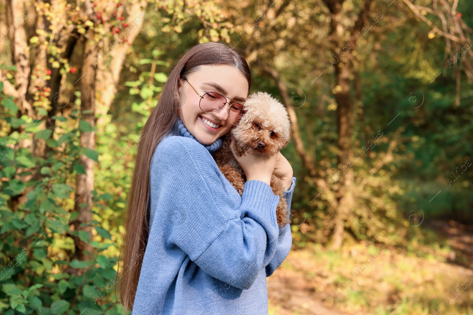 Photo of Smiling woman with cute dog in autumn park