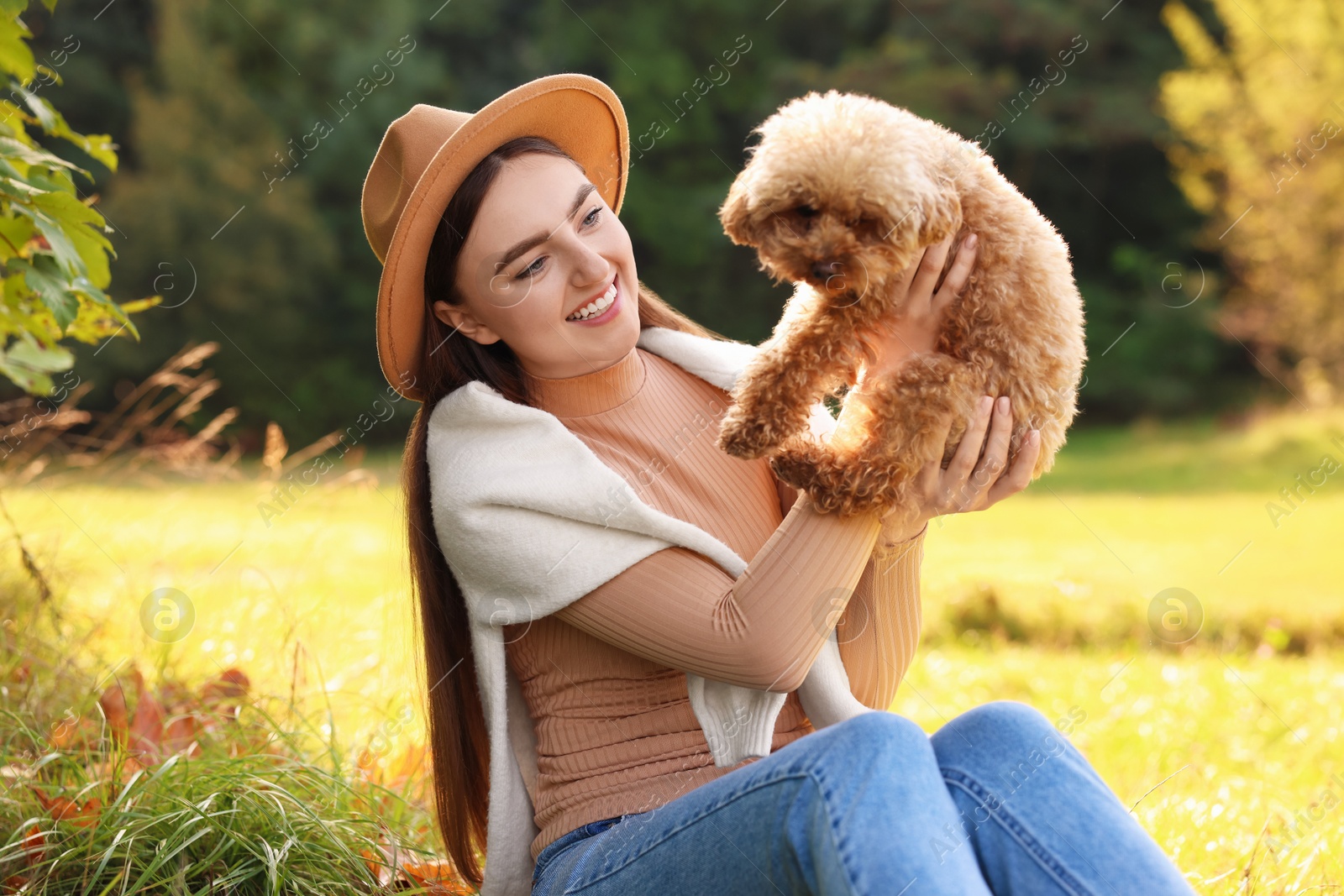 Photo of Smiling woman with cute dog in autumn park