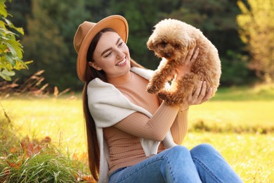 Smiling woman with cute dog in autumn park