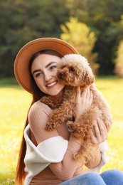 Photo of Smiling woman with cute dog in autumn park