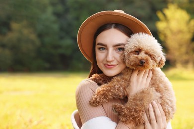 Woman with cute dog outdoors on sunny day. Space for text