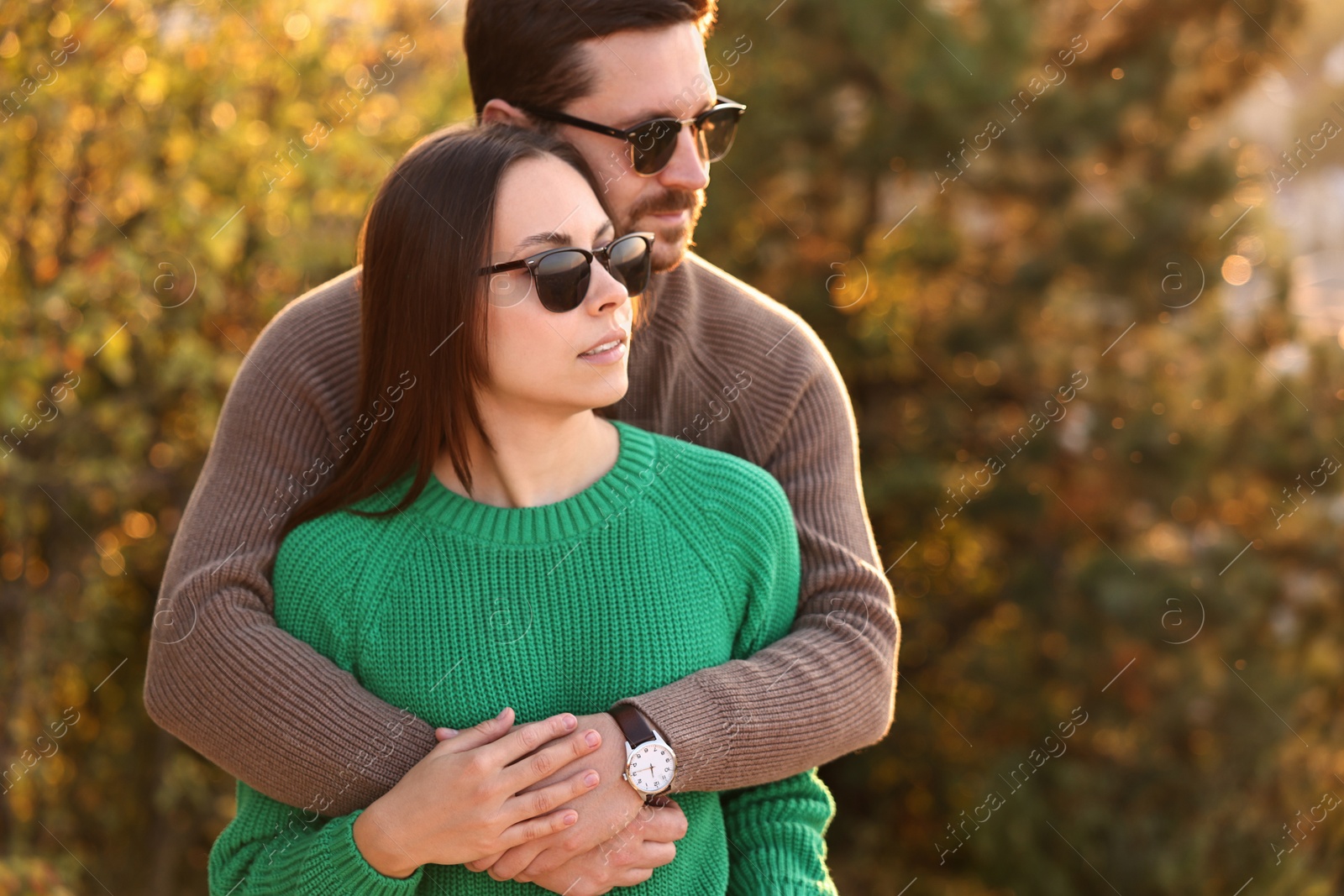 Photo of Beautiful couple hugging outdoors in autumn evening, space for text