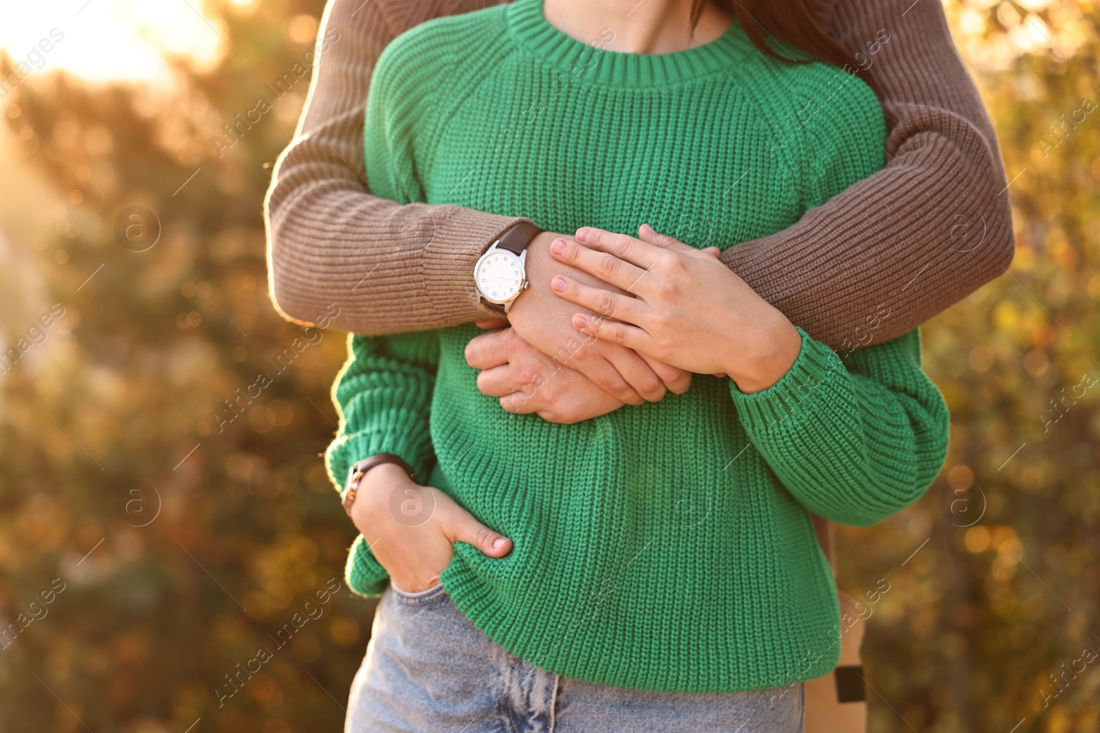 Photo of Couple hugging outdoors in autumn evening, closeup view