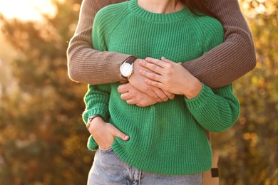 Couple hugging outdoors in autumn evening, closeup view