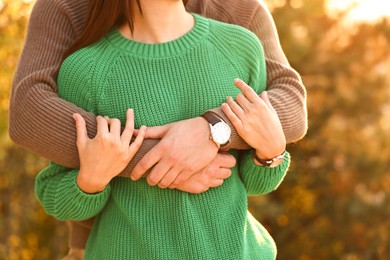 Couple hugging outdoors in autumn evening, closeup view