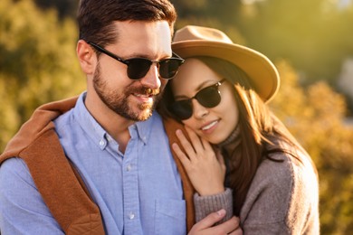 Beautiful happy couple in sunglasses outdoors on autumn day