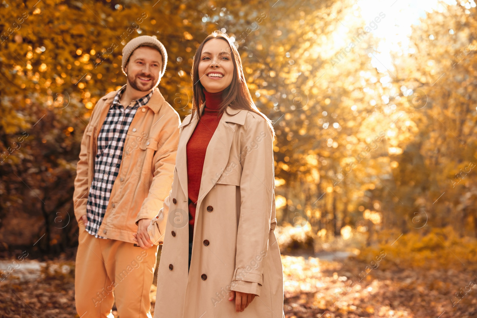 Photo of Beautiful couple walking together in autumn park, selective focus