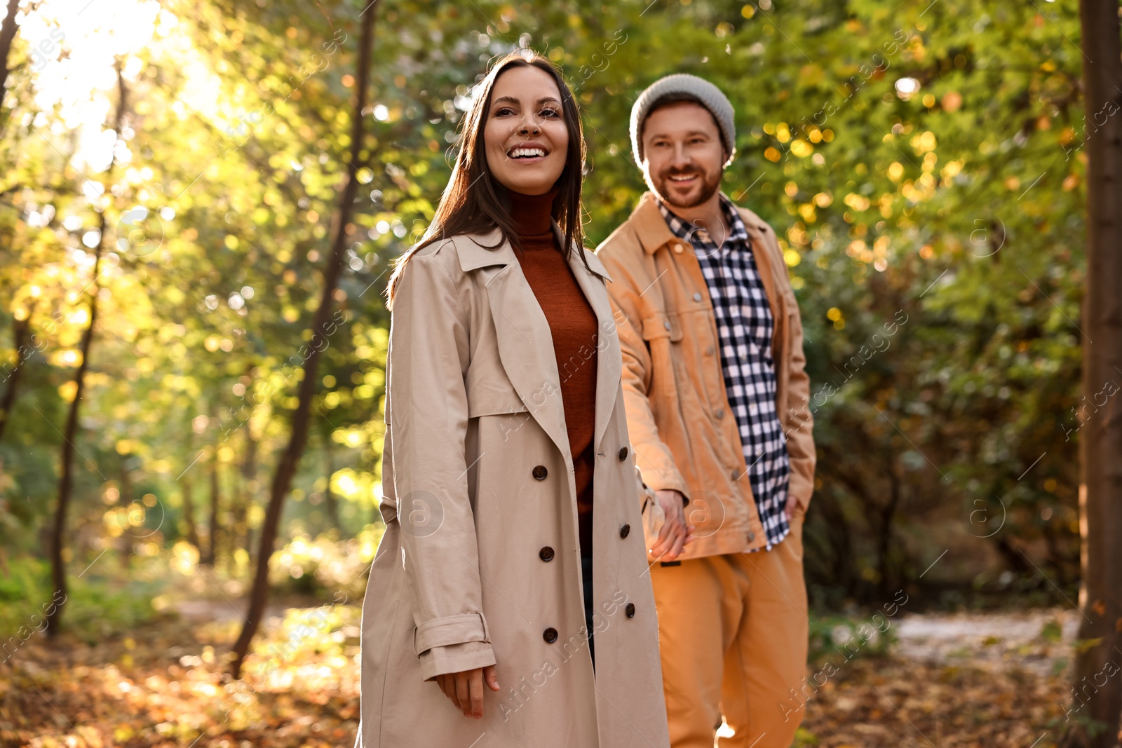 Photo of Beautiful couple walking together in autumn park, selective focus