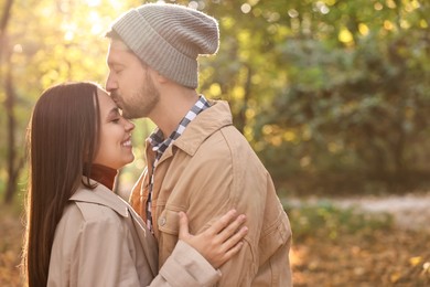 Beautiful couple spending time in park on autumn day, space for text