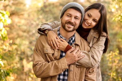 Beautiful happy couple hugging outdoors on autumn day