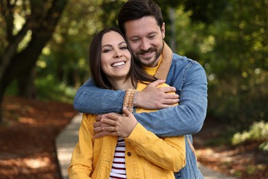 Beautiful couple hugging in park on autumn day