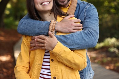 Couple hugging in autumn park, closeup view