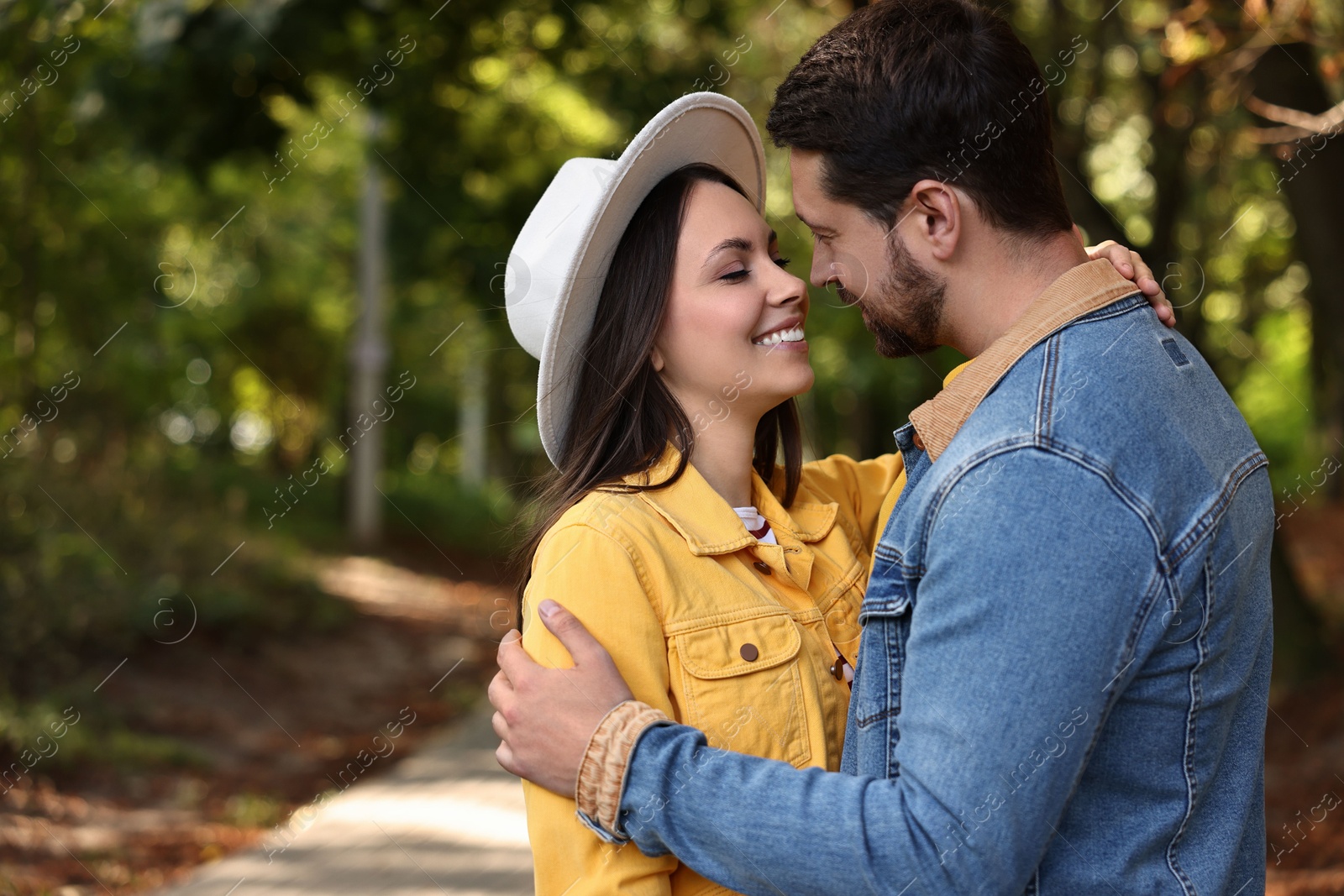 Photo of Beautiful couple hugging in park on autumn day, space for text