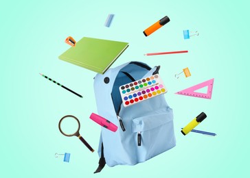 Image of Light blue backpack and school stationery in air on turquoise background