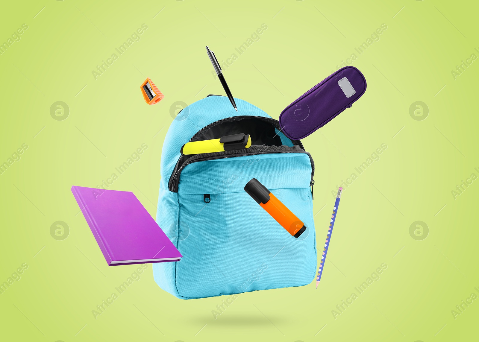 Image of Backpack and school stationery in air on light green background