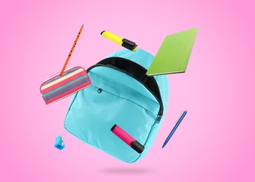 Image of Light blue backpack and school stationery in air on pink background