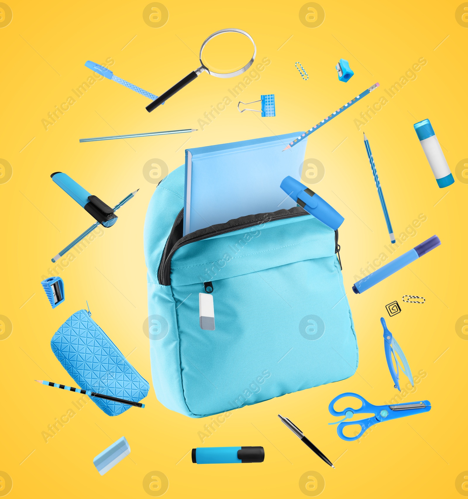 Image of Light blue backpack and school stationery in air on golden background