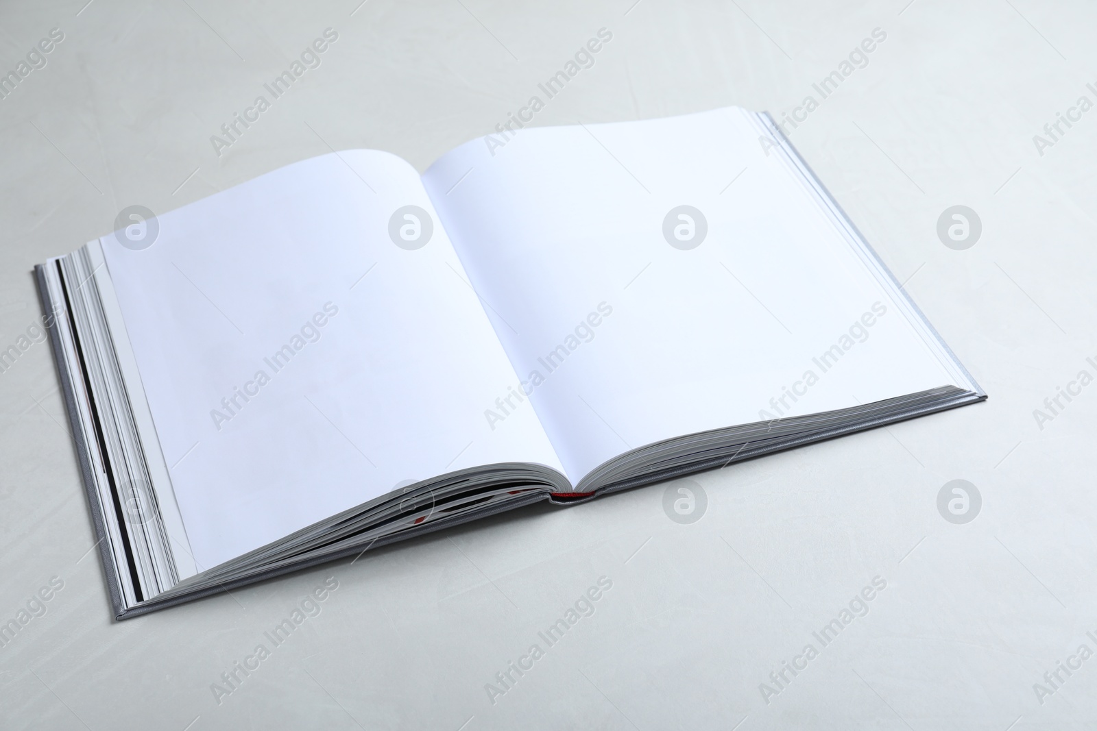 Photo of Open book with hard cover on light grey table