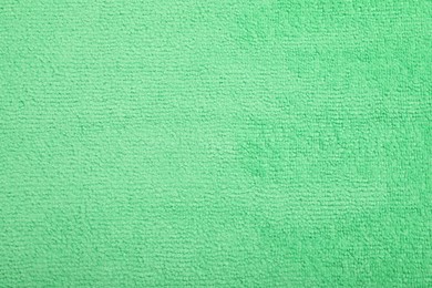 Photo of Light green microfiber cloth as background, top view