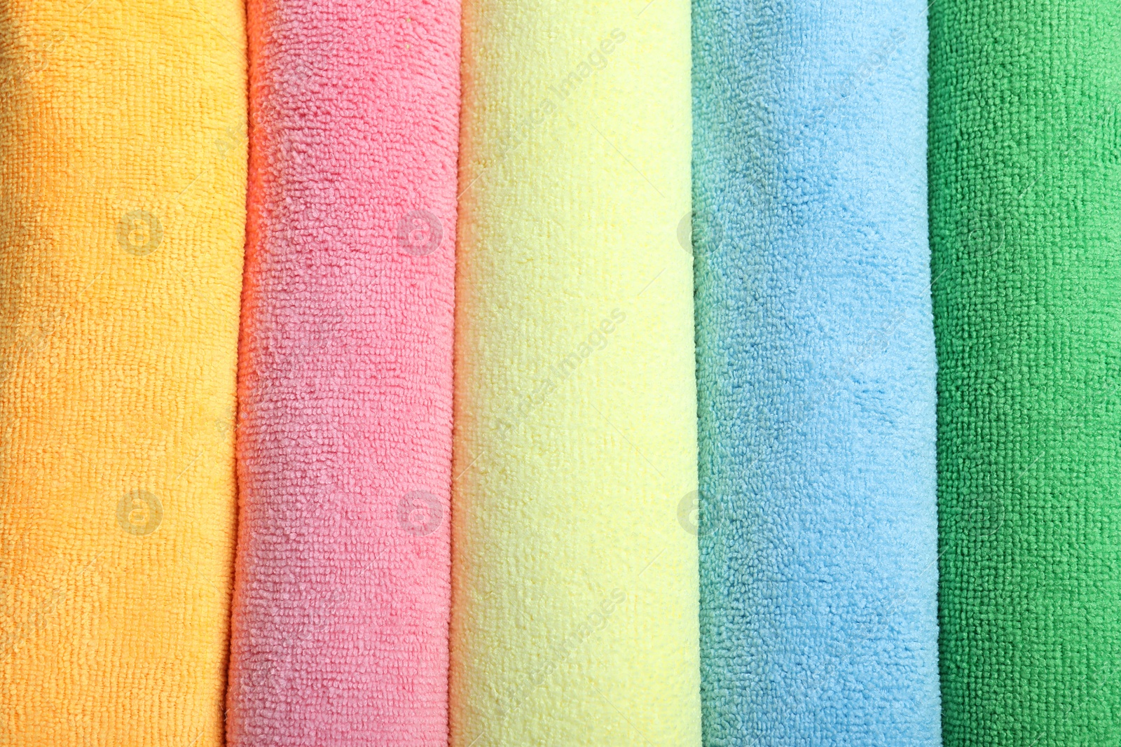 Photo of Many colorful microfiber cloths as background, top view