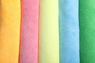 Photo of Many colorful microfiber cloths as background, top view