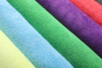 Photo of Many colorful microfiber cloths as background, closeup