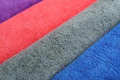 Many colorful microfiber cloths as background, closeup