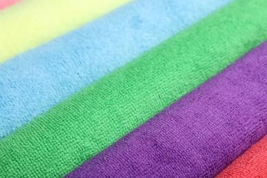 Photo of Many colorful microfiber cloths as background, closeup