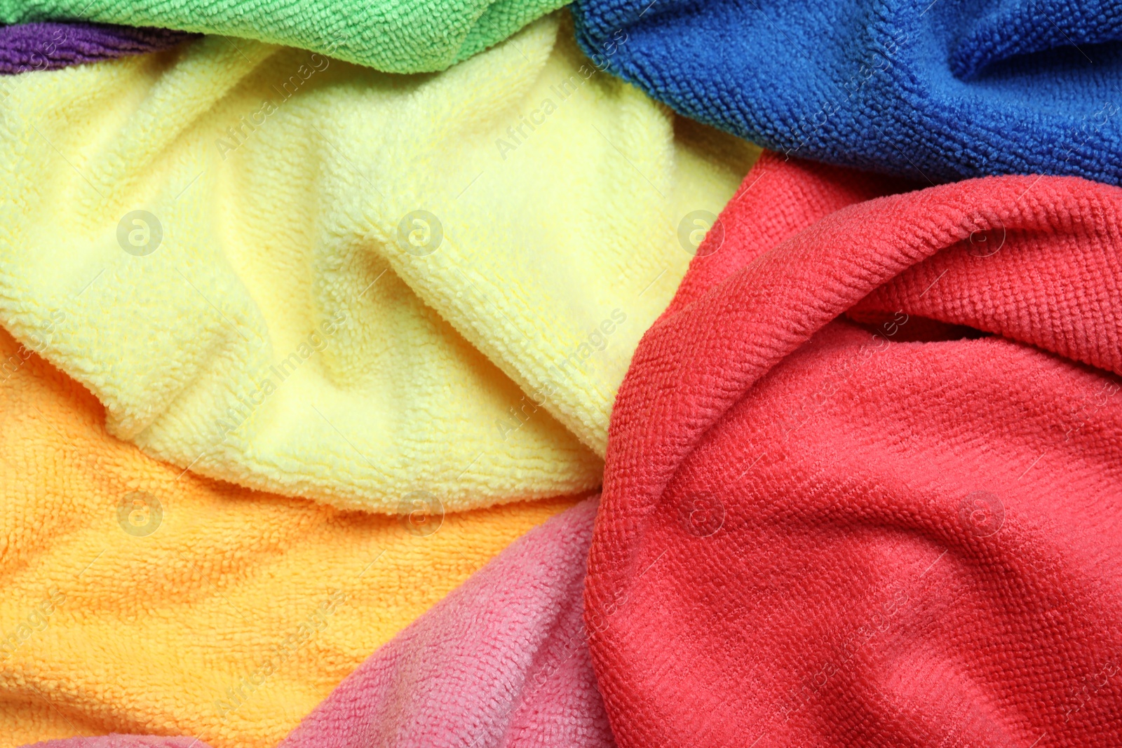 Photo of Many colorful microfiber cloths as background, closeup